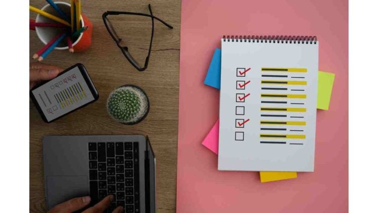 A notebook with a checklist on it next to a laptop used for Donotpay reviews.