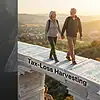 IRMAA limit cliff edge metaphor illustrating retirement income threshold and tax-loss harvesting concept with senior couple walking on large financial documents in scenic outdoor setting.